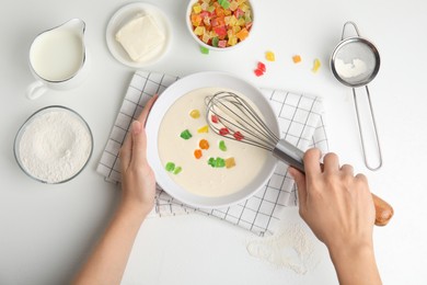 Photo of Woman making cookies with candied fruits at white table, top view