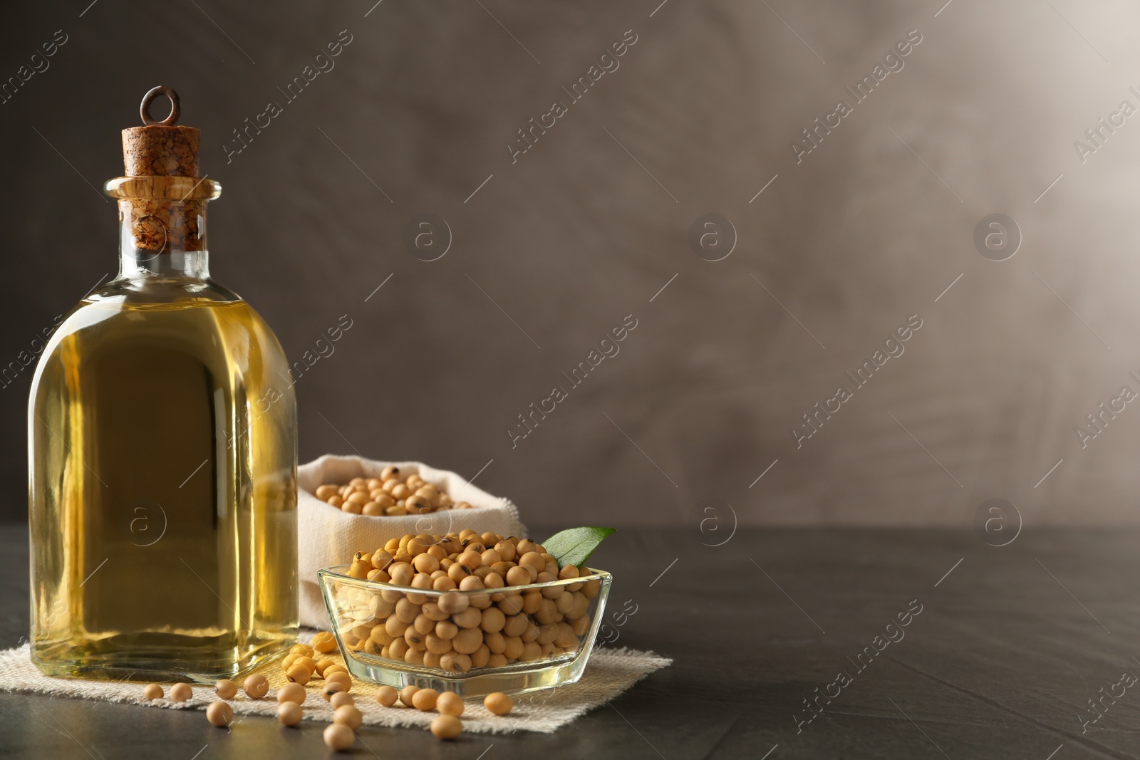 Photo of Composition with soybean oil on grey table. Space for text