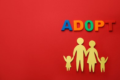 Photo of Family figure and word Adopt on red background, flat lay. Space for text