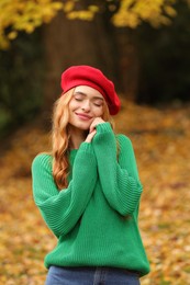 Photo of Beautiful woman wearing warm sweater in autumn park