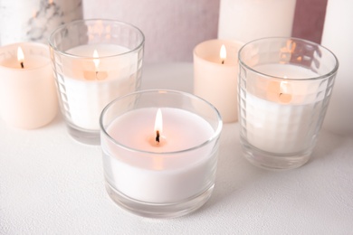 Photo of Burning aromatic candles in holders on table