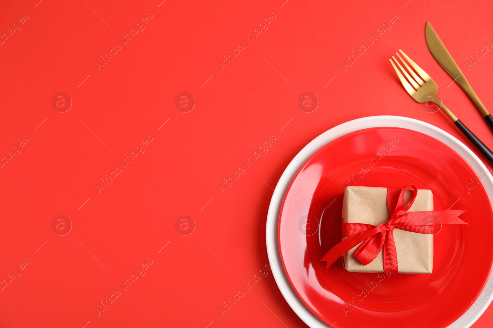 Photo of Romantic table setting on red background, flat lay with space for text. Valentine's day celebration