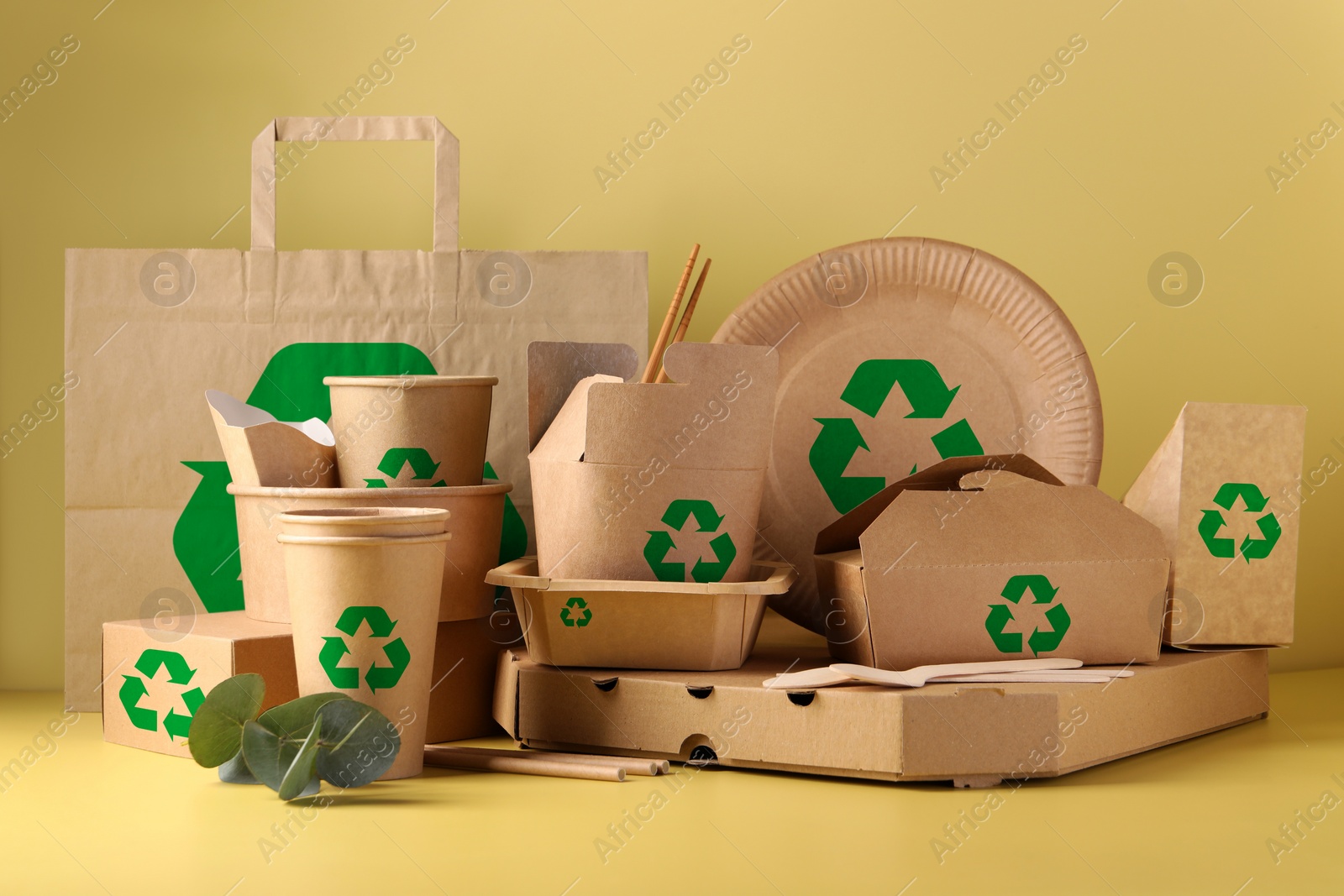 Image of Set of eco friendly food packaging with recycling symbols on yellow background