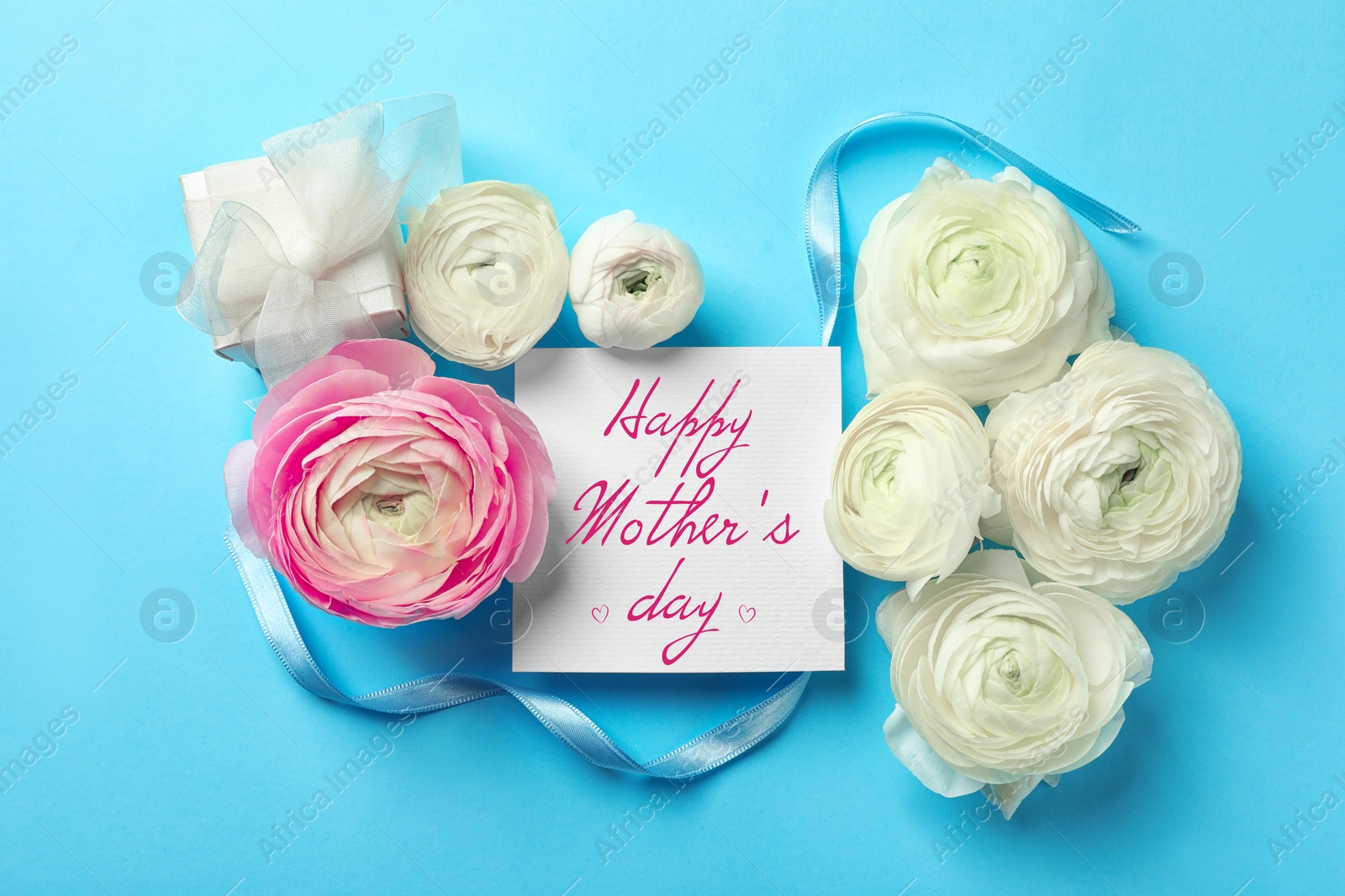 Image of Happy Mother's Day greeting card, beautiful ranunculus flowers and ribbon on light blue background, flat lay