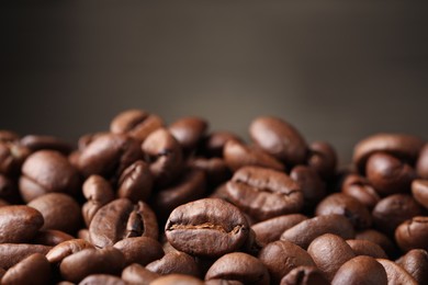 Photo of Heap of aromatic roasted coffee beans, closeup