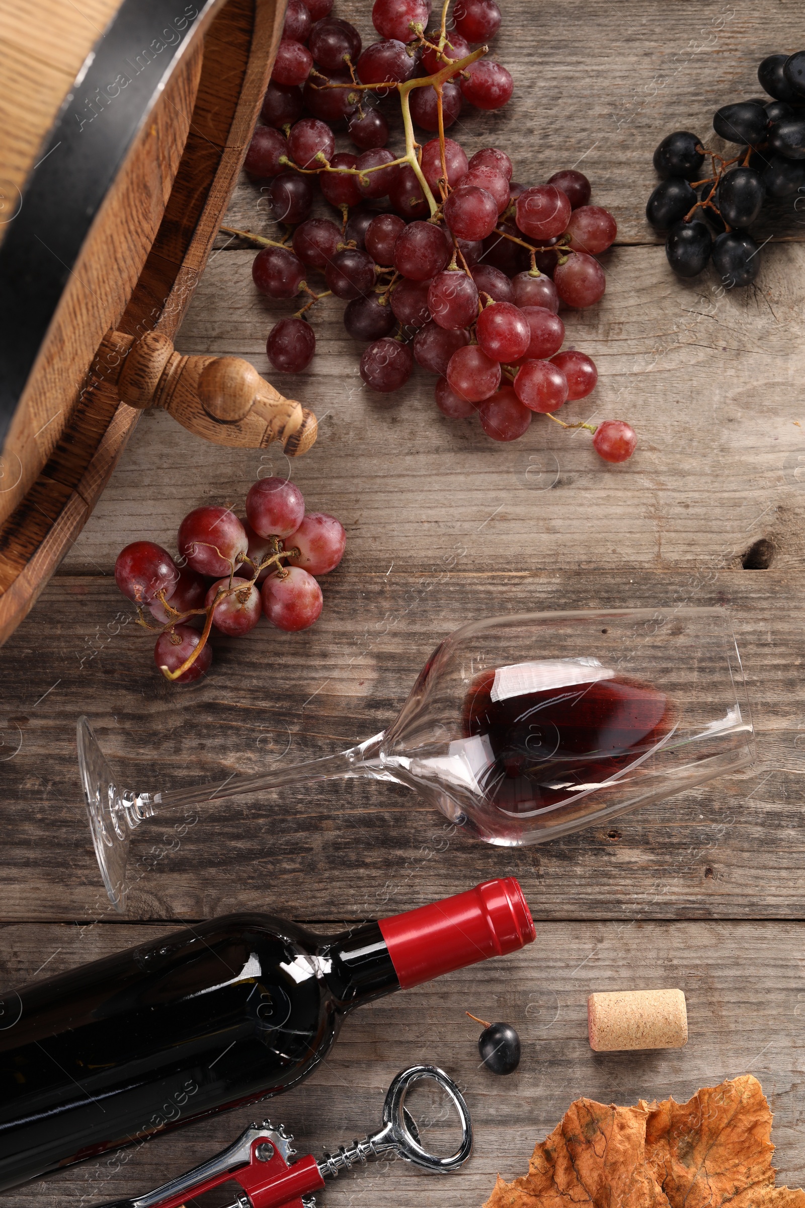 Photo of Winemaking. Flat lay composition with tasty wine and barrel on wooden table