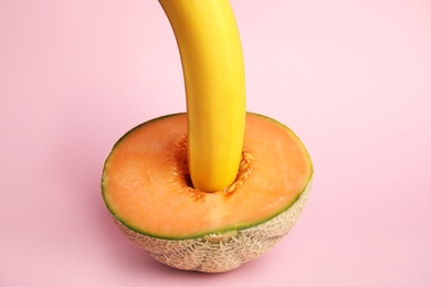 Photo of Fresh melon and banana on pink background. Sex concept