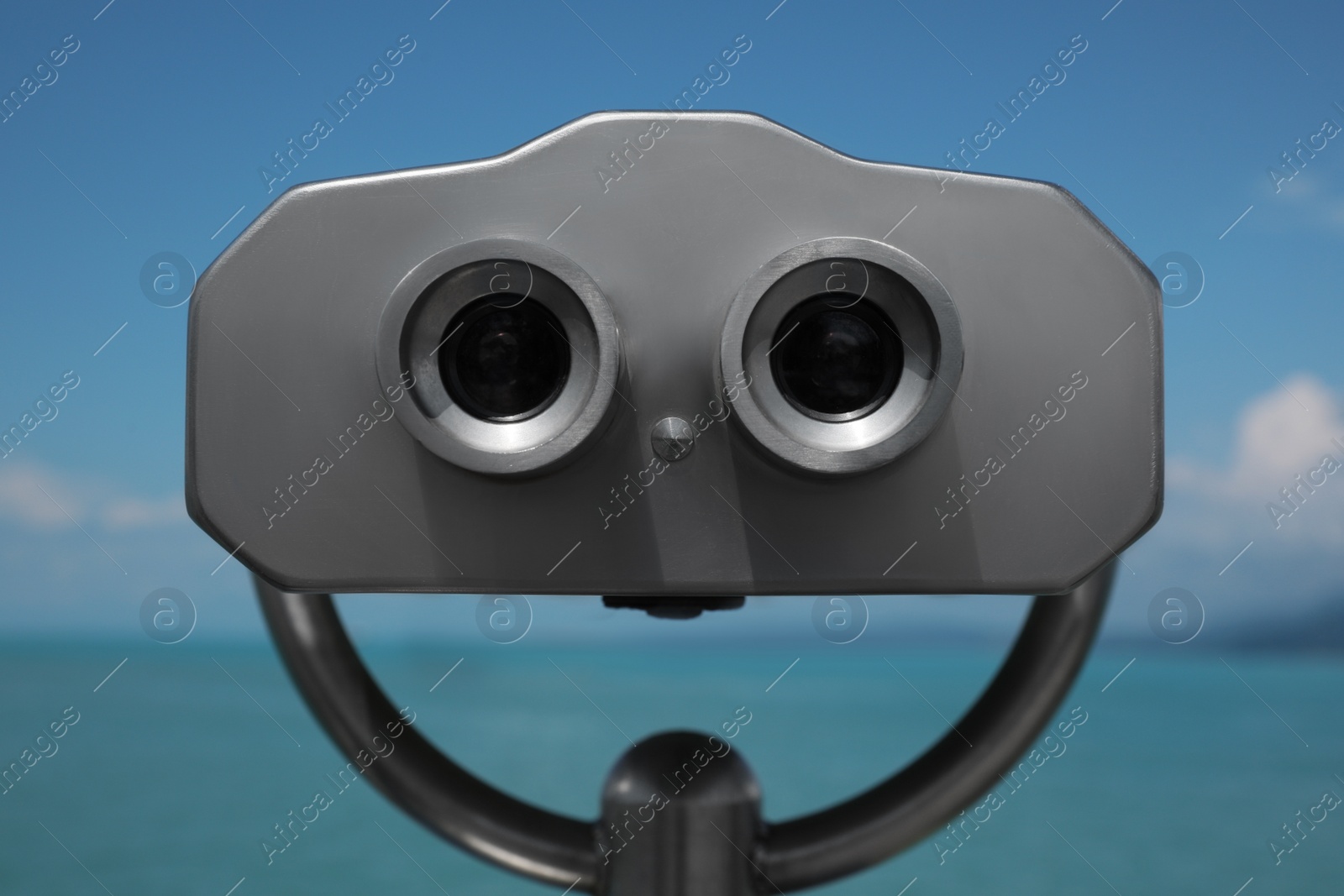 Photo of Metal tower viewer installed near sea, closeup. Mounted binoculars