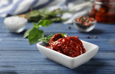 Photo of Dried tomatoes in bowl on table. Healthy snack