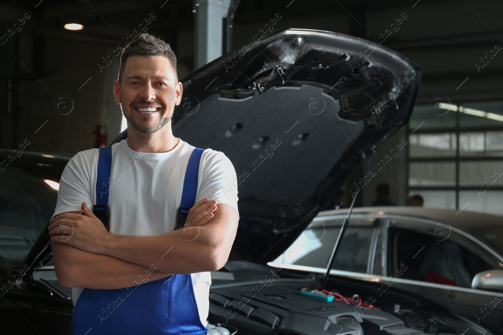 Photo of Mechanic near automobile in service center, space for text. Car diagnostic