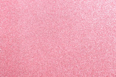 Photo of Beautiful pink shiny glitter as background, top view