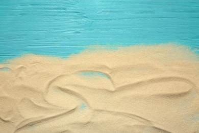 Photo of Beach sand on wooden background, top view with space for text