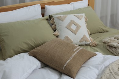 Photo of Large comfortable bed with soft pillows and duvet in room. Home textile