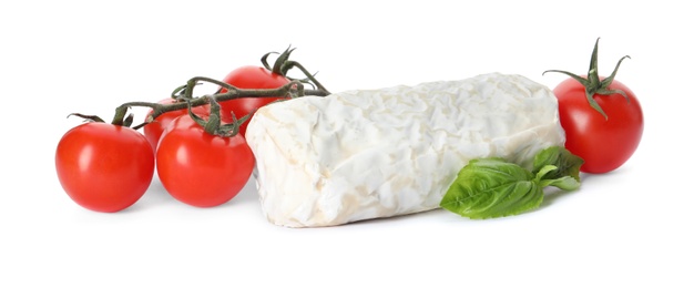 Photo of Delicious fresh goat cheese with basil and cherry tomatoes on white background