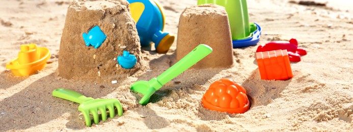 Set of plastic beach toys on sand near sea. Banner design