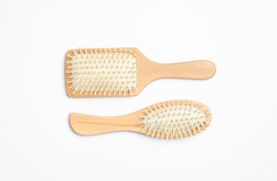 Wooden hair brushes on white background, top view