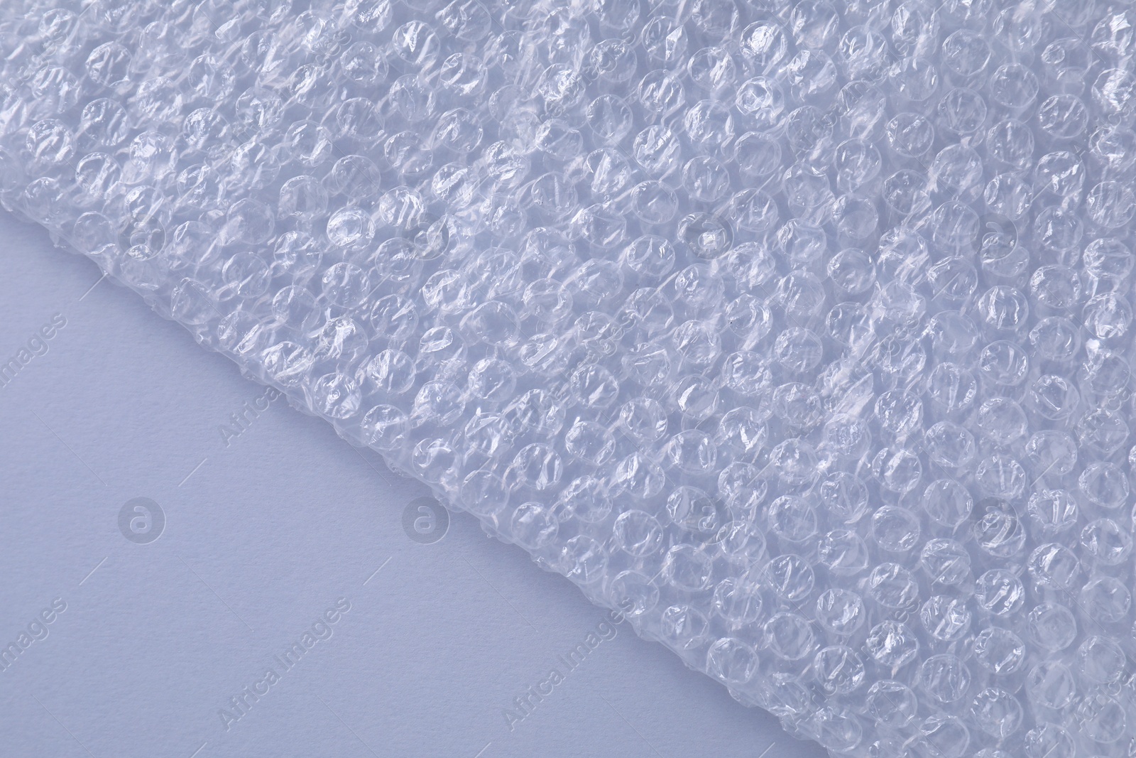 Photo of Transparent bubble wrap on gray background, top view. Space for text