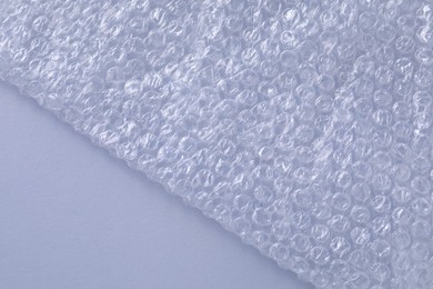 Photo of Transparent bubble wrap on gray background, top view. Space for text