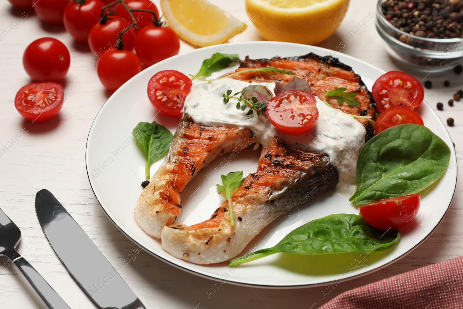 Photo of Tasty salmon steak served on white wooden table, closeup