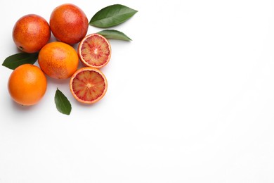 Photo of Ripe sicilian oranges and leaves on white background, flat lay. Space for text