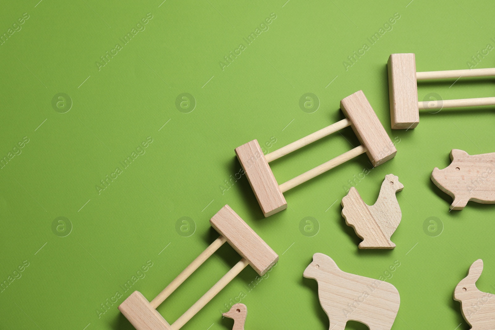 Photo of Wooden animals and fence on green background, flat lay with space for text. Children's toy