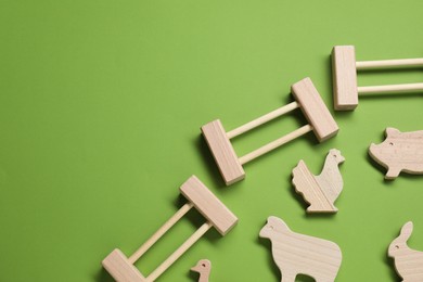 Photo of Wooden animals and fence on green background, flat lay with space for text. Children's toy
