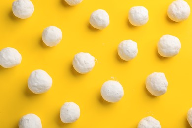 Round snowballs on yellow background, flat lay