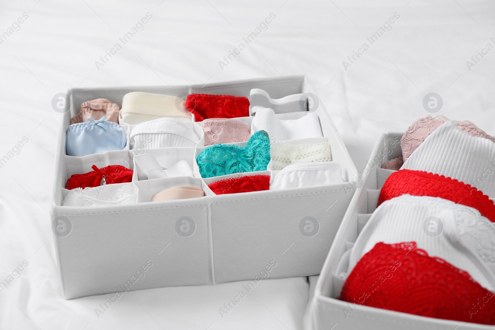 Photo of Organizers with stylish women's underwear on bed