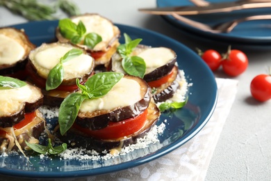 Photo of Baked eggplant with tomatoes, cheese and basil on table, closeup