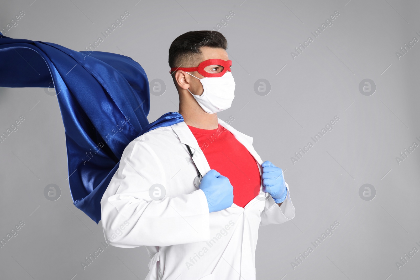 Photo of Doctor wearing face mask and cape on grey background. Super hero power for medicine