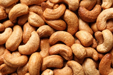 Tasty cashew nuts as background, top view