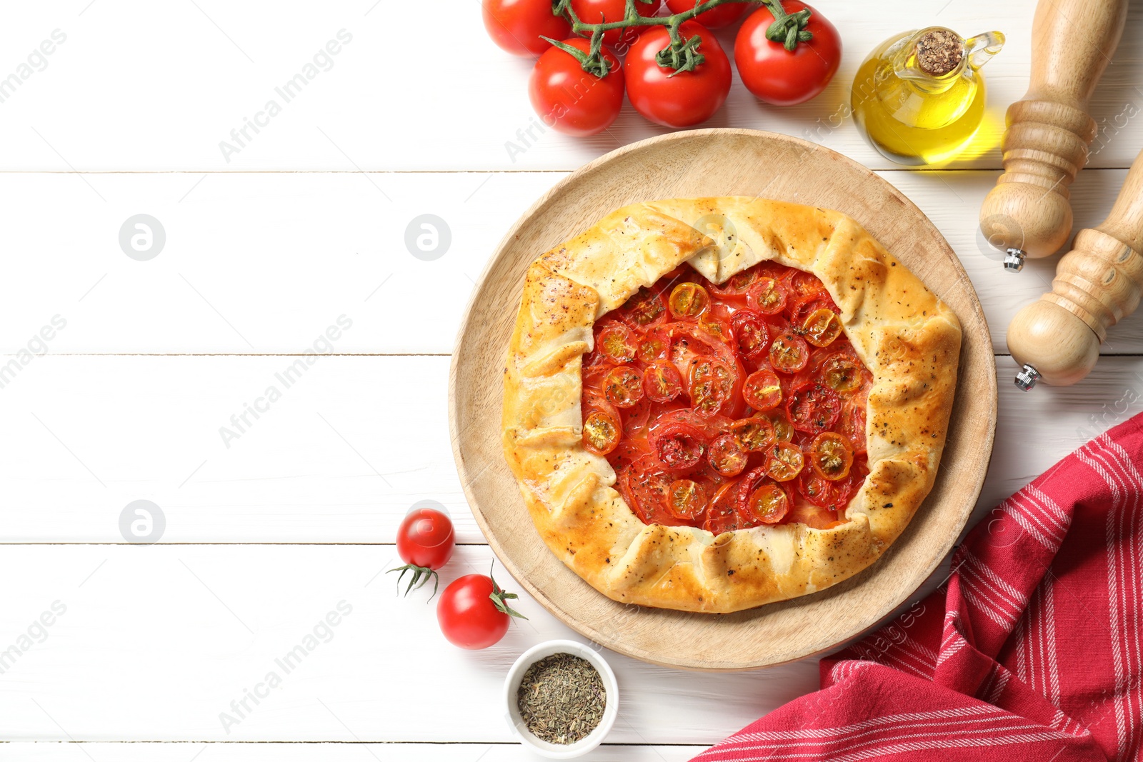 Photo of Flat lay composition with tasty tomato galette (Caprese galette) on white wooden table. Space for text