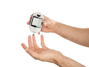 Photo of Man checking blood sugar level with glucometer on white background. Diabetes test