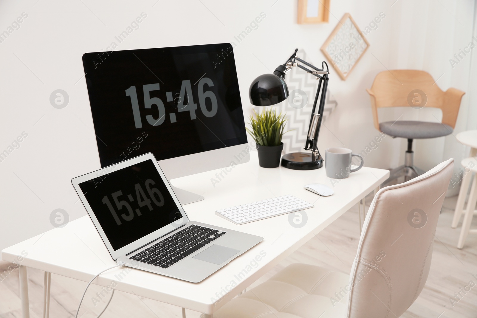 Photo of Stylish workplace with computers on table in room