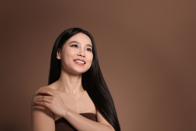 Portrait of beautiful woman on brown background, space for text