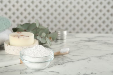 Photo of Tooth powder, brush and soap on white marble table, space for text
