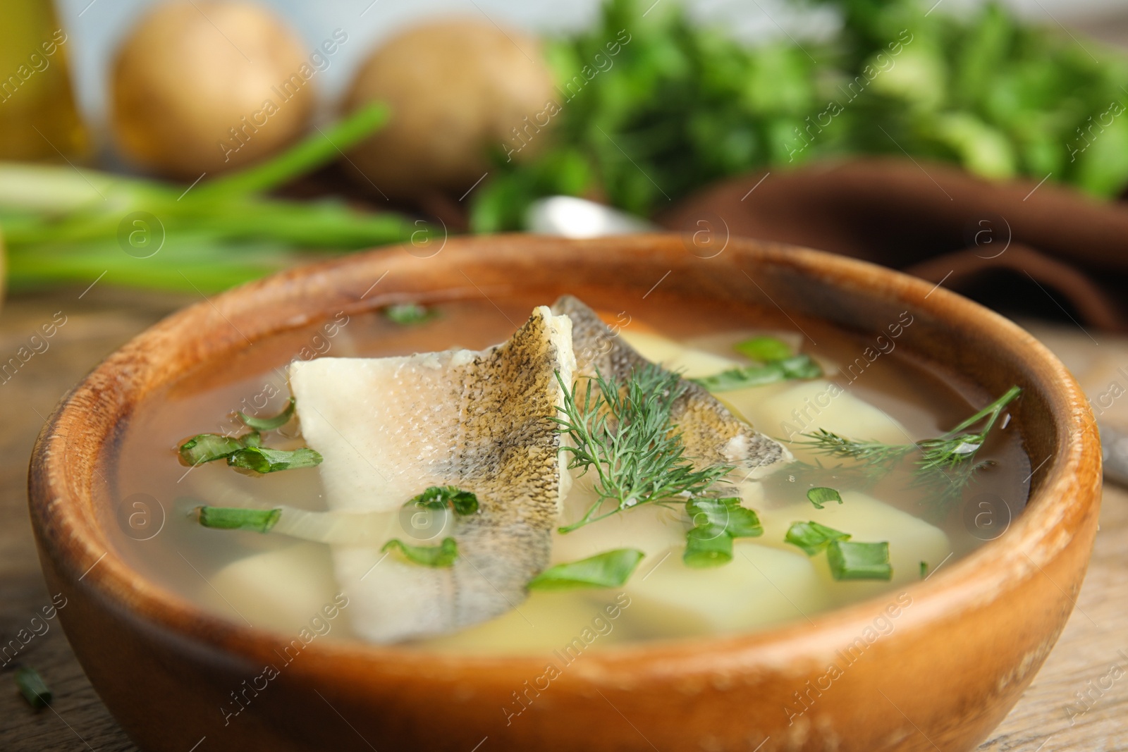 Photo of Delicious fish soup in bowl on table, closeup view
