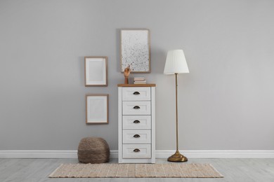 Photo of Modern room interior with chest of drawers near light wall