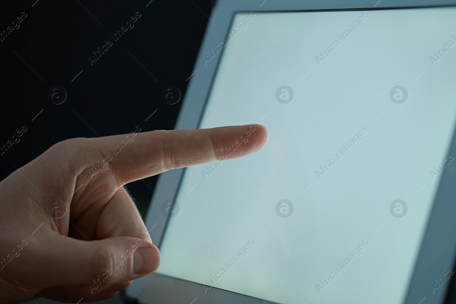 Photo of Man using tablet at night, closeup view