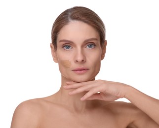 Woman with swatch of foundation on face against white background