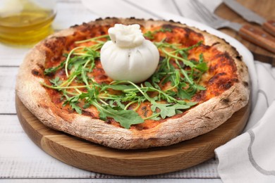 Delicious pizza with burrata cheese and arugula on white wooden table, closeup