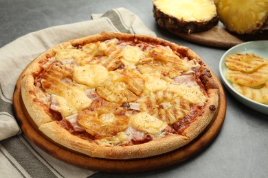 Photo of Delicious pineapple pizza on gray table, closeup