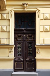 Entrance of house with beautiful wooden door, elegant moldings and transom window