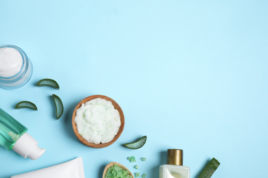 Flat lay composition with aloe vera and cosmetic products on light blue background. Space for text