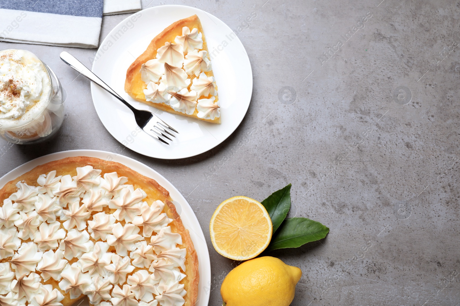 Photo of Cut delicious lemon meringue pie served on grey table, flat lay. Space for text