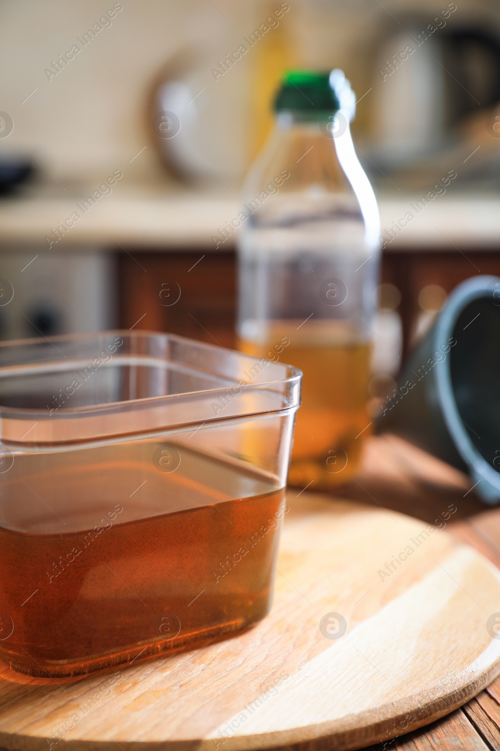 Photo of Used cooking oil on wooden table in kitchen, closeup