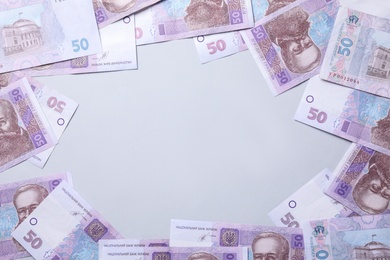 Photo of Frame of Ukrainian money on light grey background, flat lay. Space for text