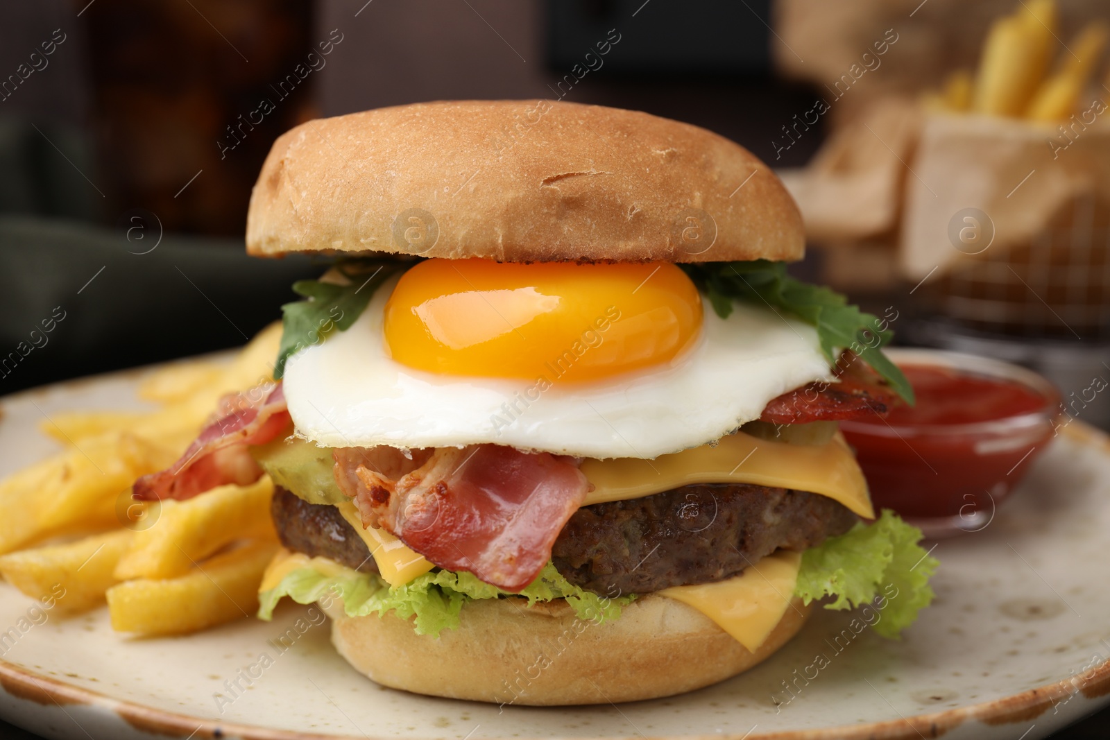 Photo of Delicious burger with fried egg and french fries on blurred background, closeup