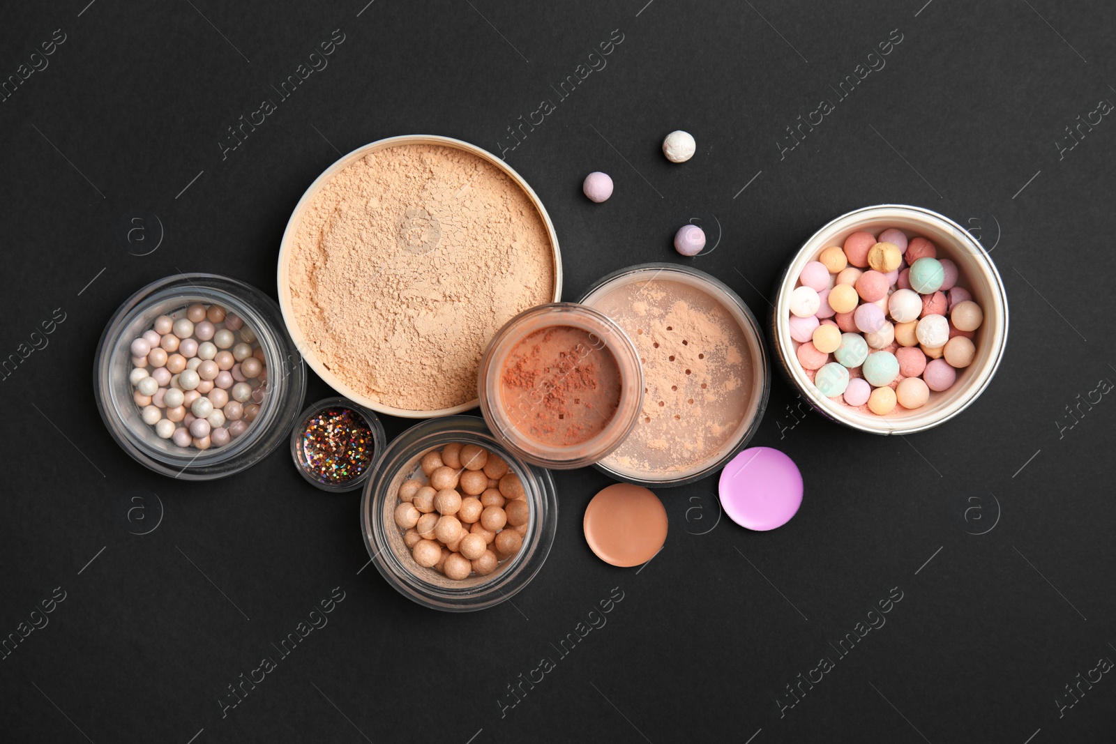 Photo of Flat lay composition with various makeup face powders on black background