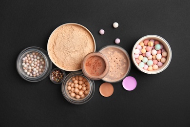 Photo of Flat lay composition with various makeup face powders on black background